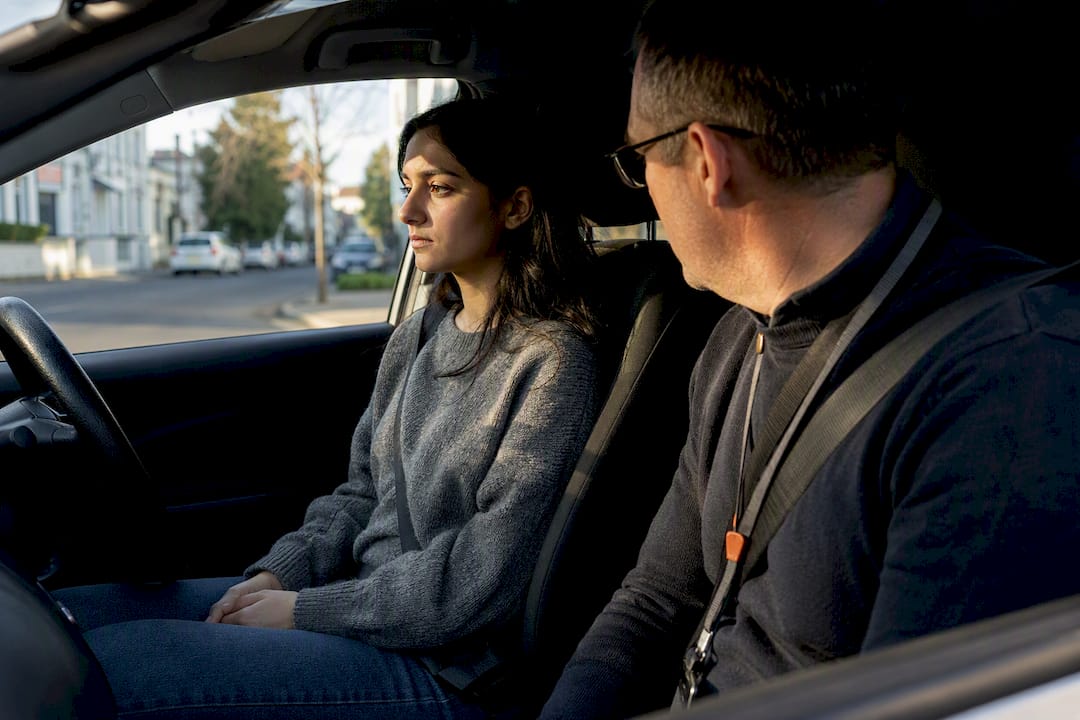 Learner and instructor pausing during driving lesson