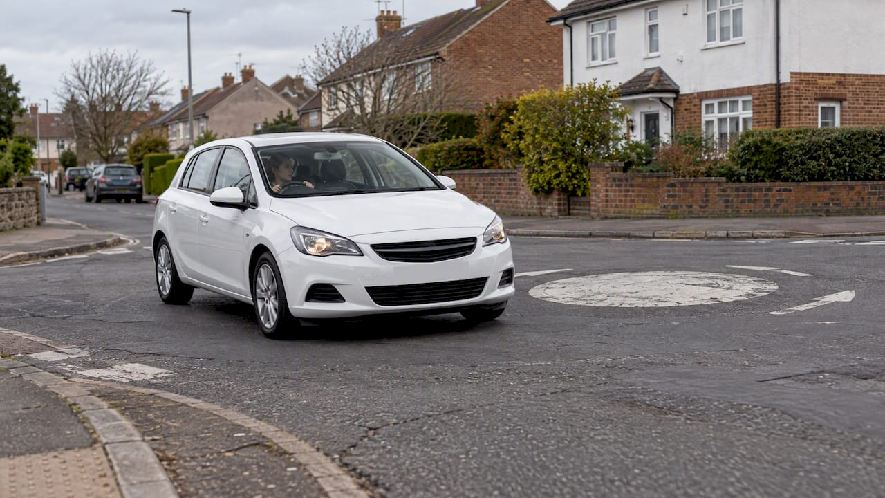 RHD car passing a mini roundabout circle